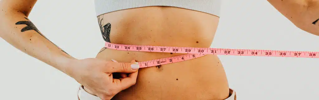 a woman with a measuring tape around her waist