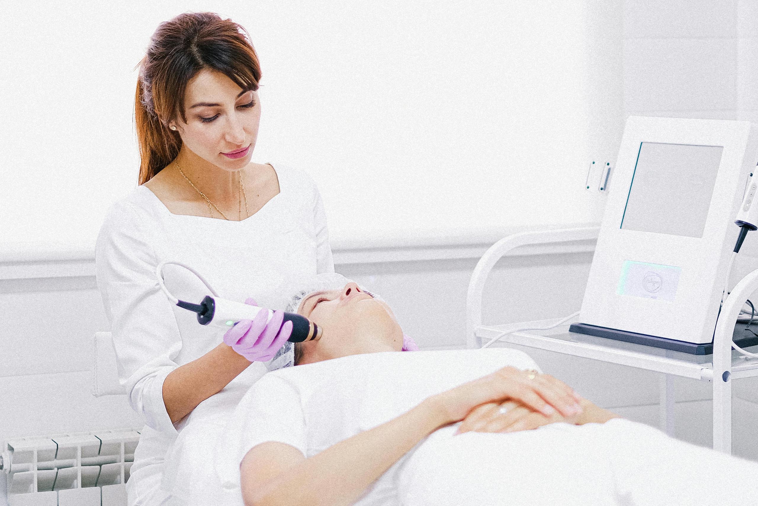 an image of a person performing a laser treatment to a patient