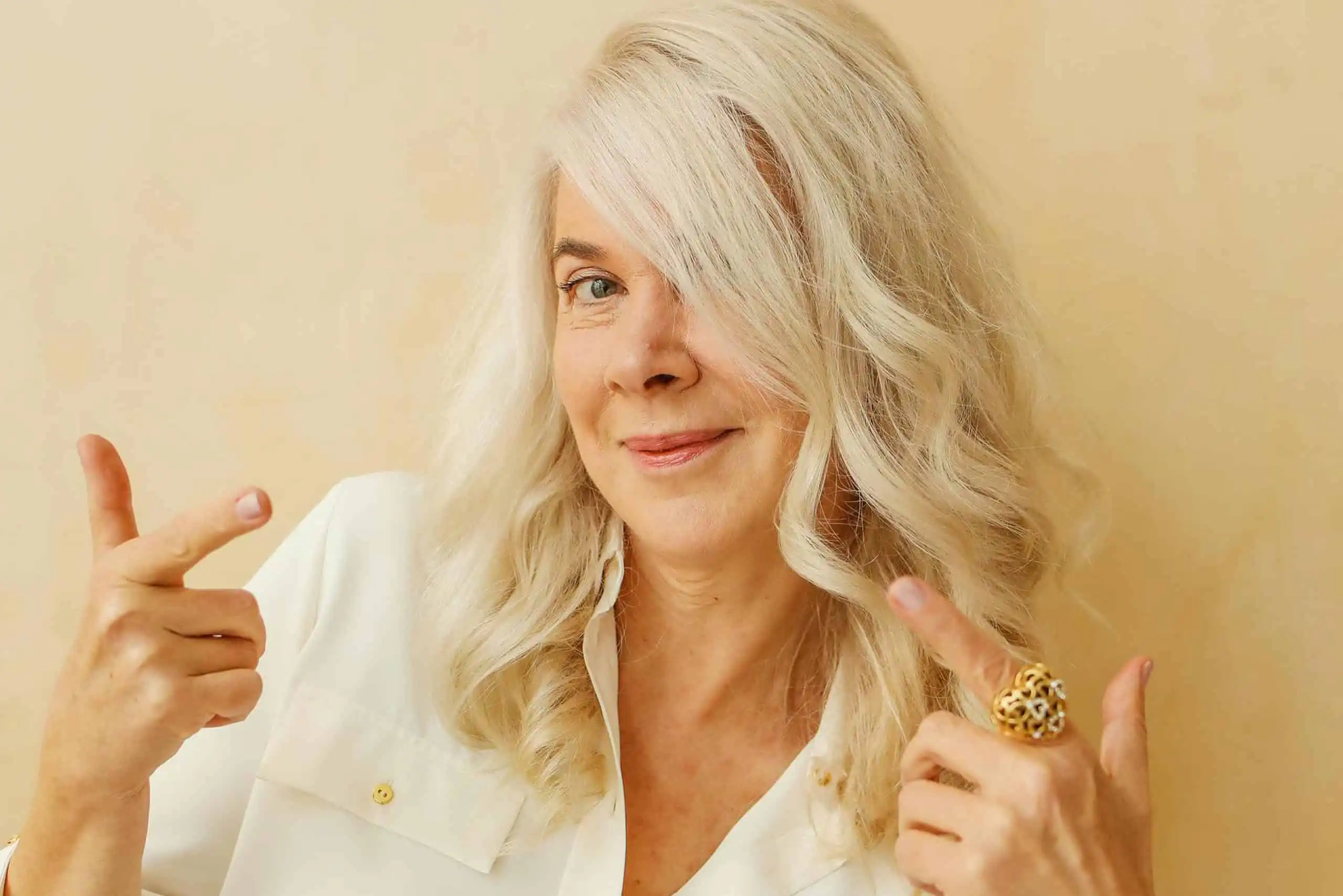 an image of an old woman smiling and striking a very quirky pose for the camera