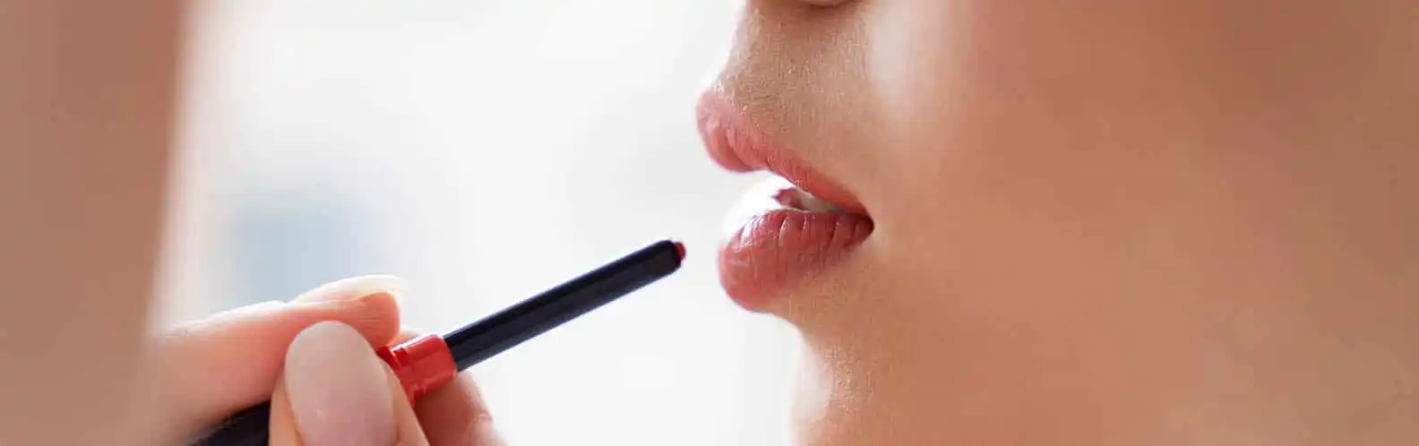 A woman applying lip liner to enhance the shape and definition of her lips, showcasing smooth, fuller results inspired by Lip Filler at Inspire Medical Spa in South Jordan, Utah.